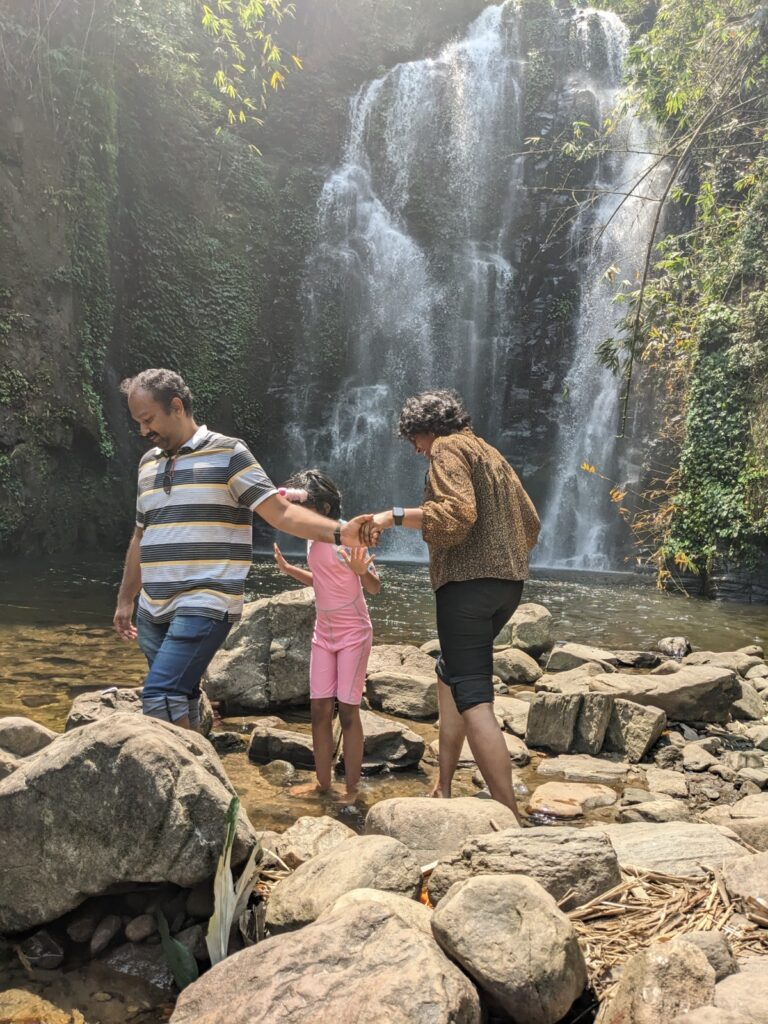A family of 3 in a waterfall - Family travel 